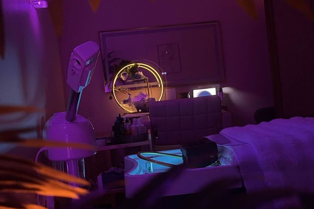 Serene Head Spa treatment room with head spa basin, steamer and gold ring light in soft purple light